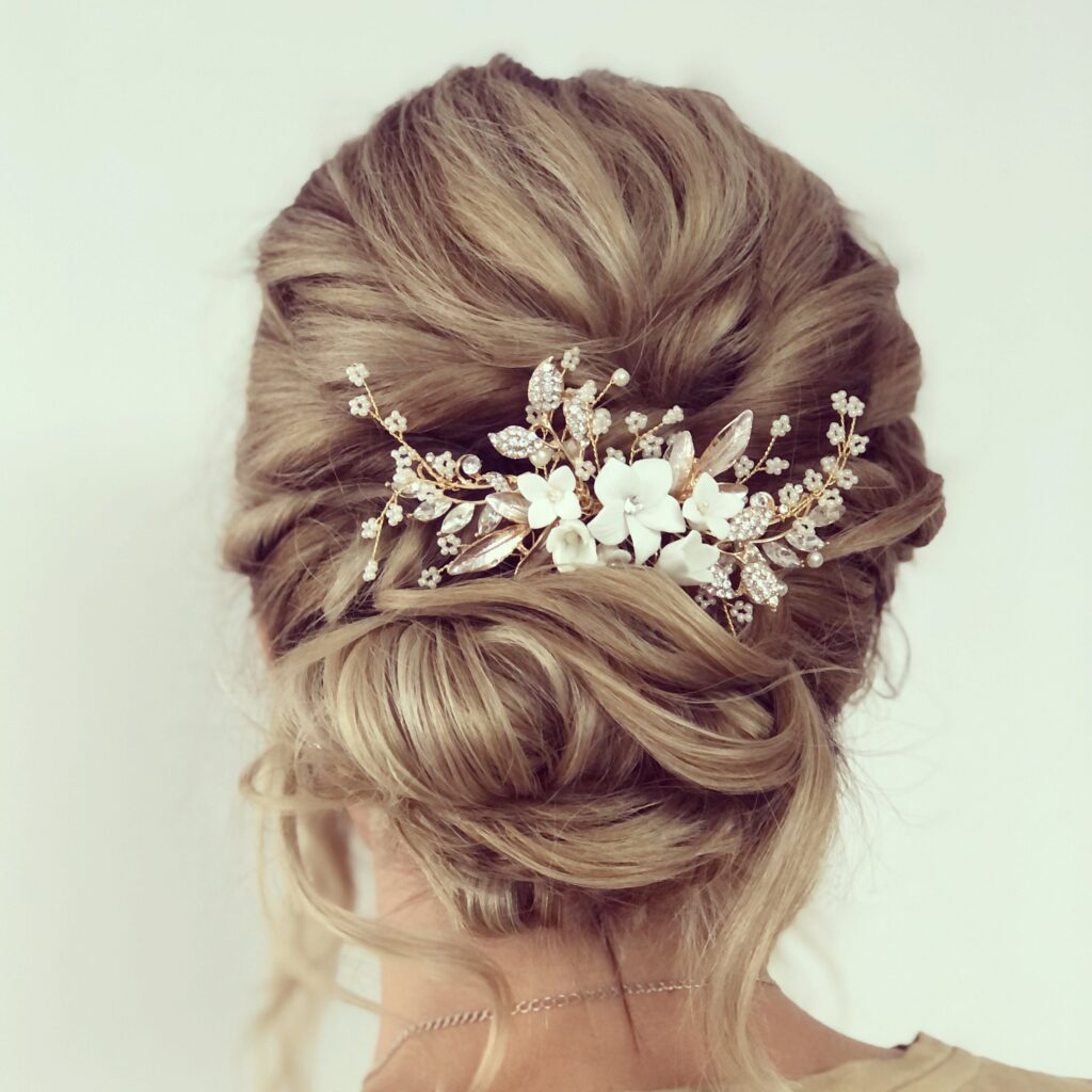 Blonde Hochsteckfrisur mit Haarschmuck aus Perlen, Kristallen und weißen Blüten von hinten