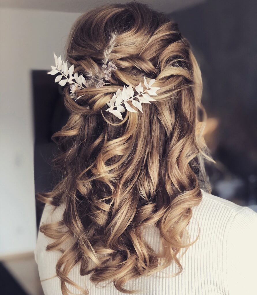 Halboffene Boho-Brautfrisur mit großen Locken und weißem Trockenblumen-Haarschmuck