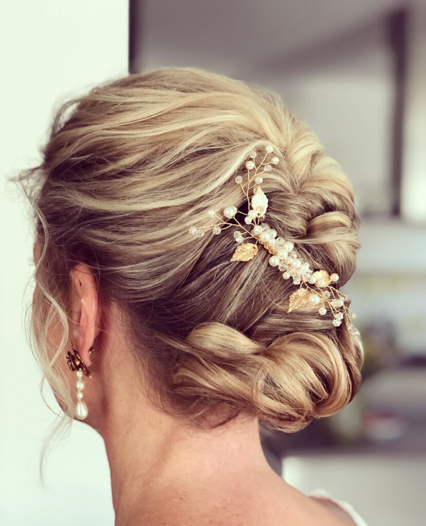 Eingedrehter French Twist in Blond mit roséfarbenem Perlen-Haarschmuck von hinten