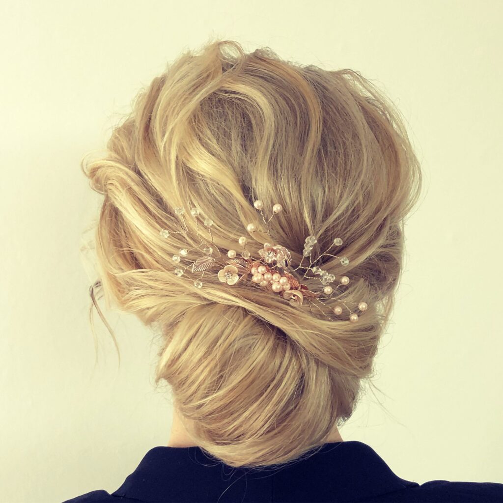 Klassischer French Twist in Blond mit goldenem Blätter- und Perlen-Haarschmuck, seitlich fotografiert