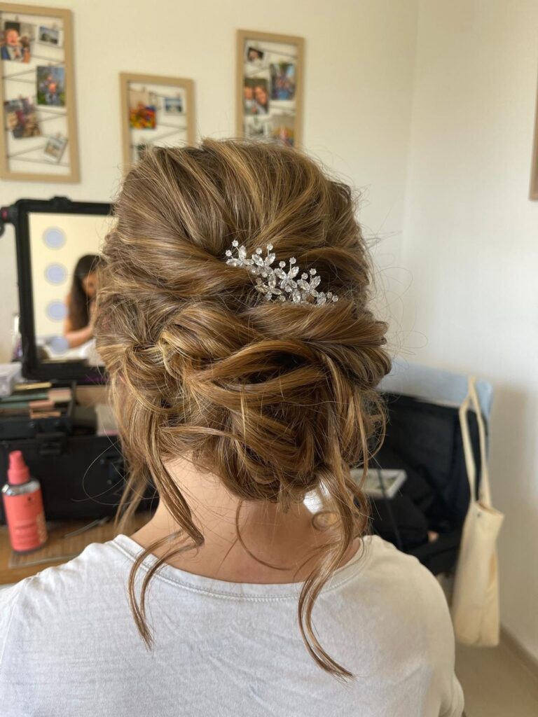Romantische Hochsteckfrisur mit gelösten Strähnen und glitzernder Haarspange von hinten
