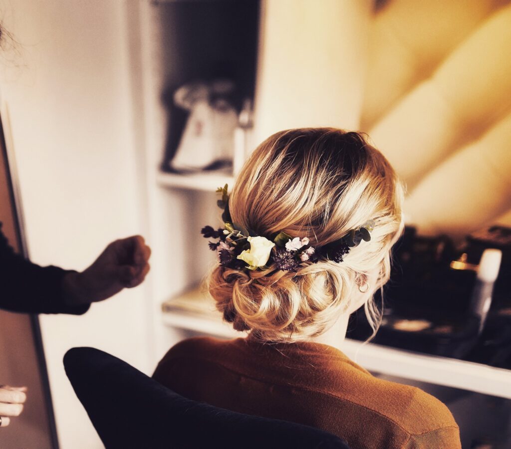 Lockerer Dutt mit Trockenblumen-Haarschmuck beim Getting Ready vor dem Spiegel