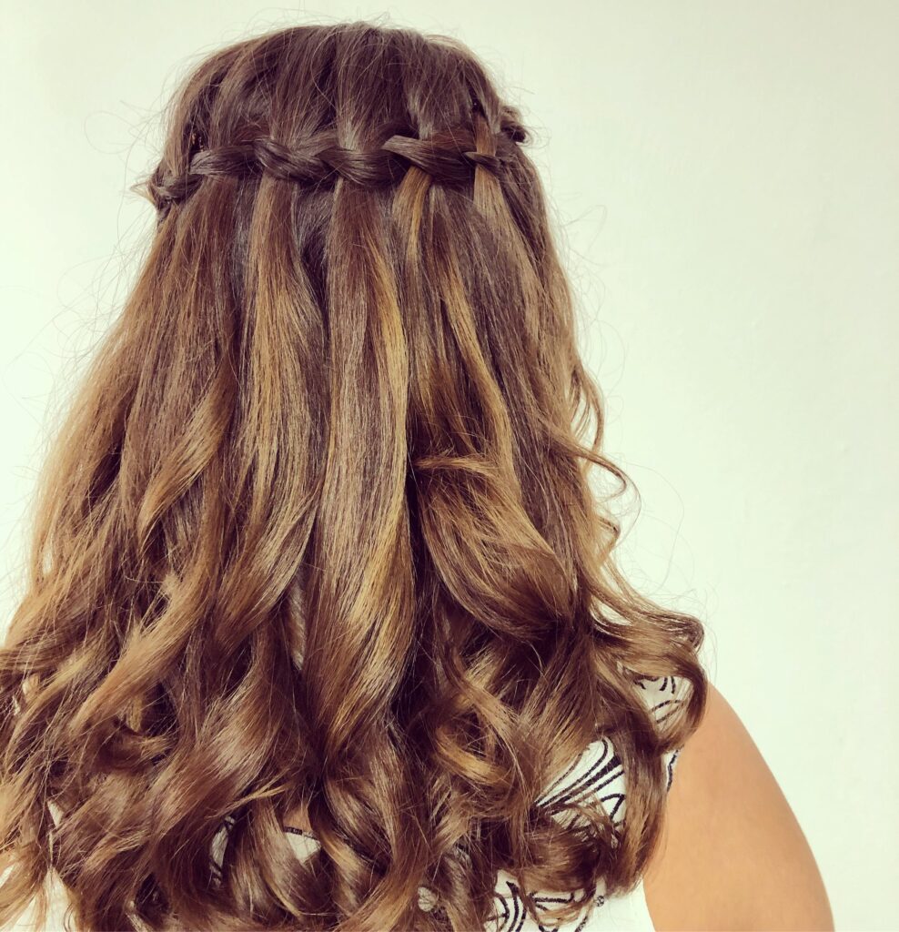 Offene Brautfrisur mit Wasserfallzopf und großen Locken bei langen braunen Haaren